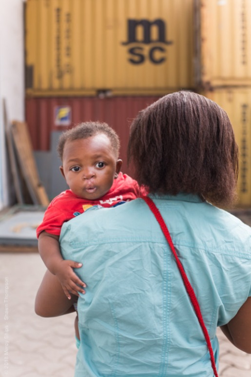 Paul Pascal over his mother's shoulder after going through the Infant Feeding Program and having his cleft lip repaired.