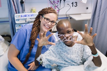 Hannah Thyberg, Pediatric Ward Nurse, playing cat's whiskers with one of her patients.